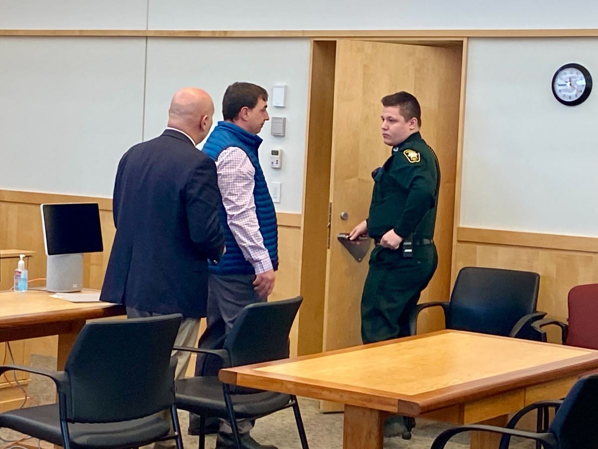 A man is led out of a courtroom.