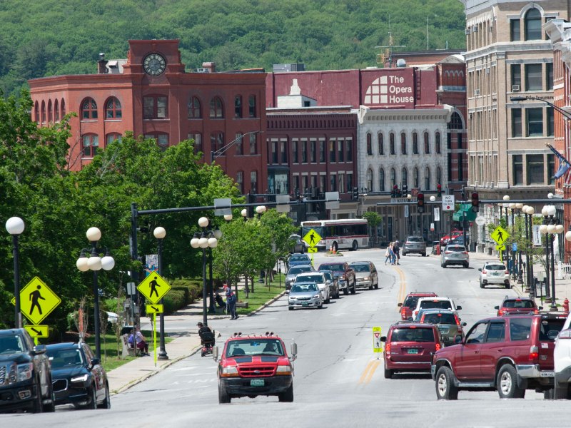Cars drive down a street in a city.