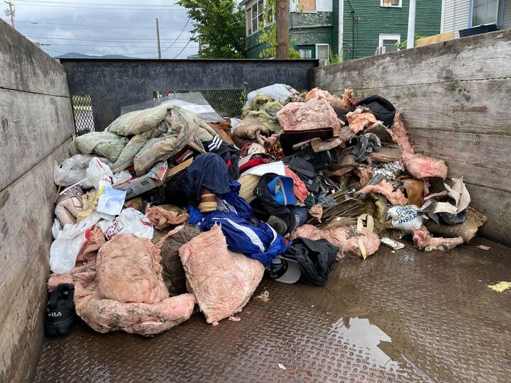 A dump truck with a lot of garbage in it.