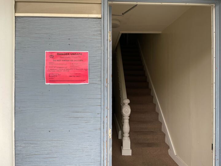 The front door of a house with a red sign on it.
