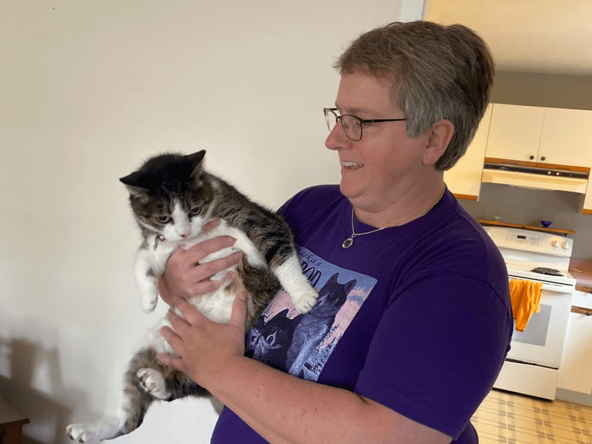 A woman holds a cat.
