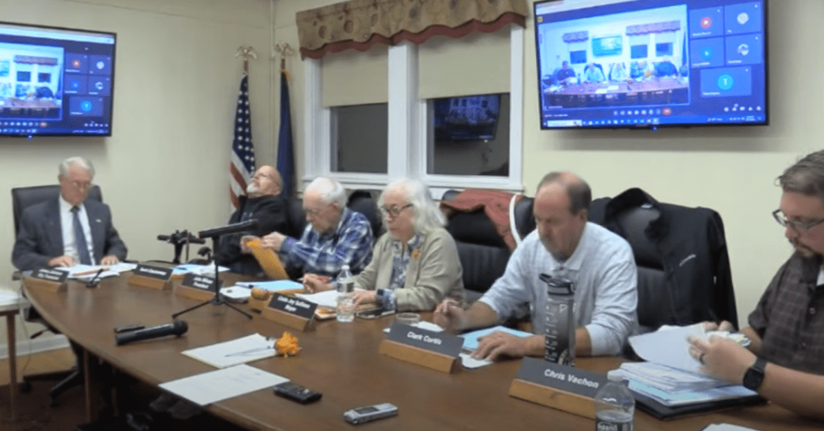 A group of people sitting around a table at a meeting.