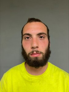 A man in a yellow shirt with a beard.