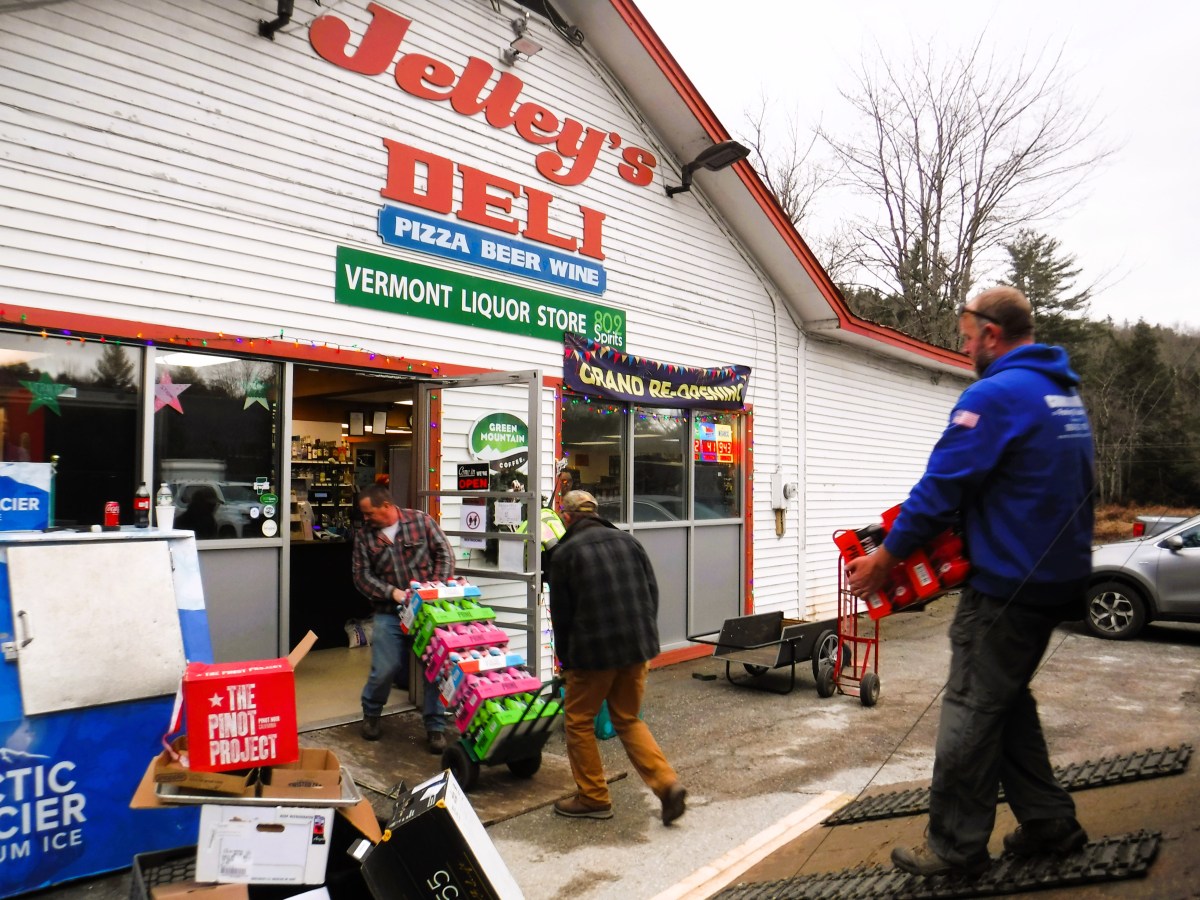 A group of people standing in front of a deli.