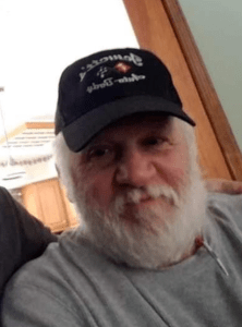 a man with a beard and a hat is posing for a photo.