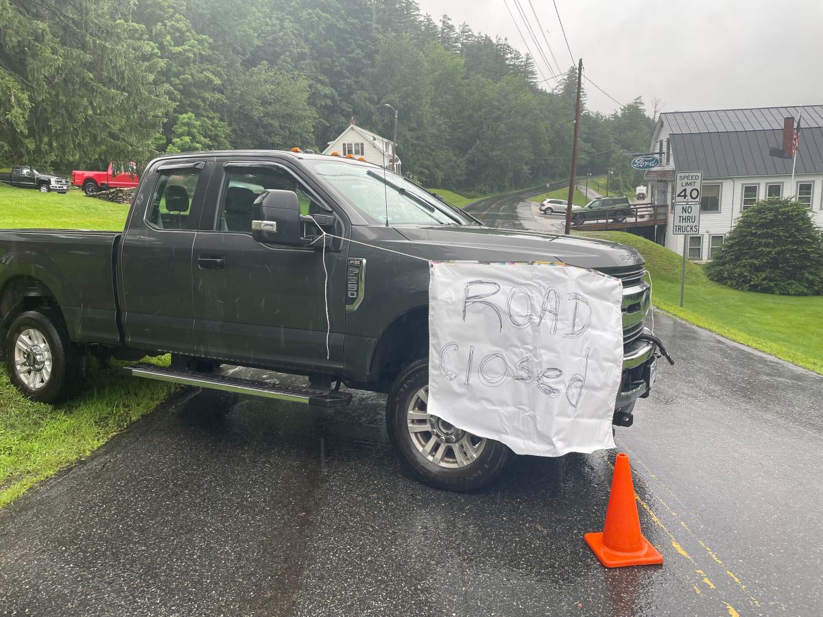 a truck is parked in the rain with a sign on it.