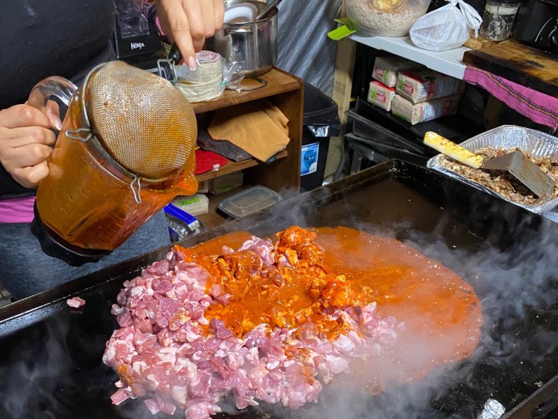 a person cooking food on top of a grill.