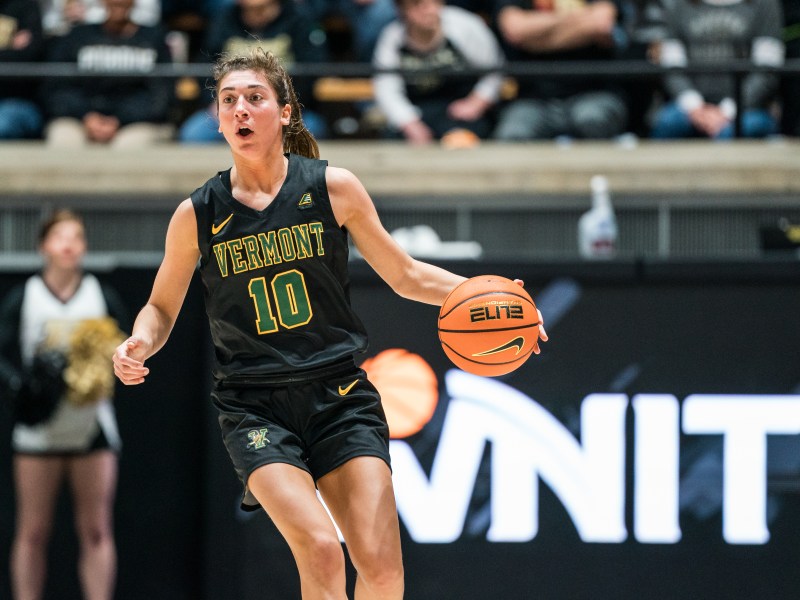 A player with No. 10 on her jersey dribbles a basketball.