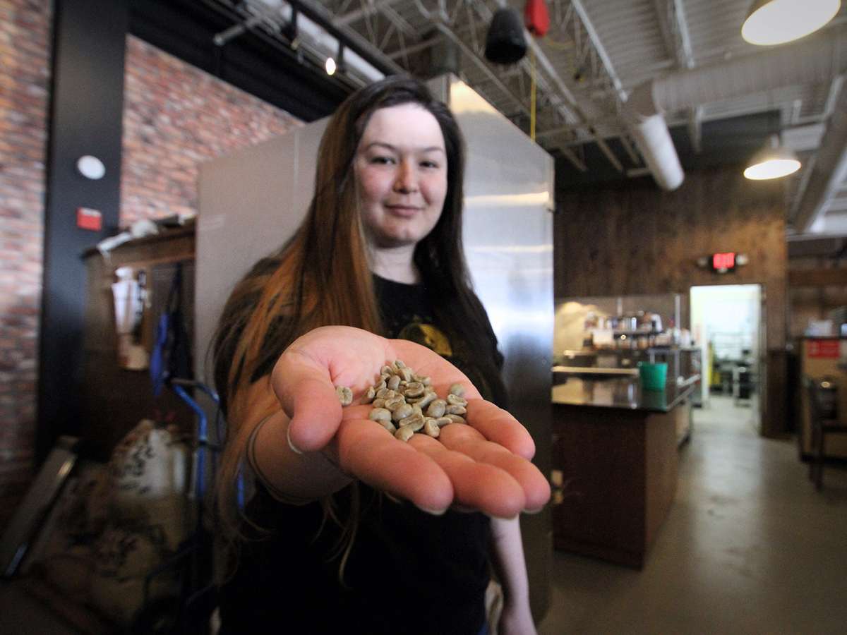 A woman is holding a handful of marijuana in her hand.