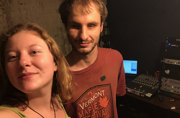 a man standing next to a woman in a recording studio.