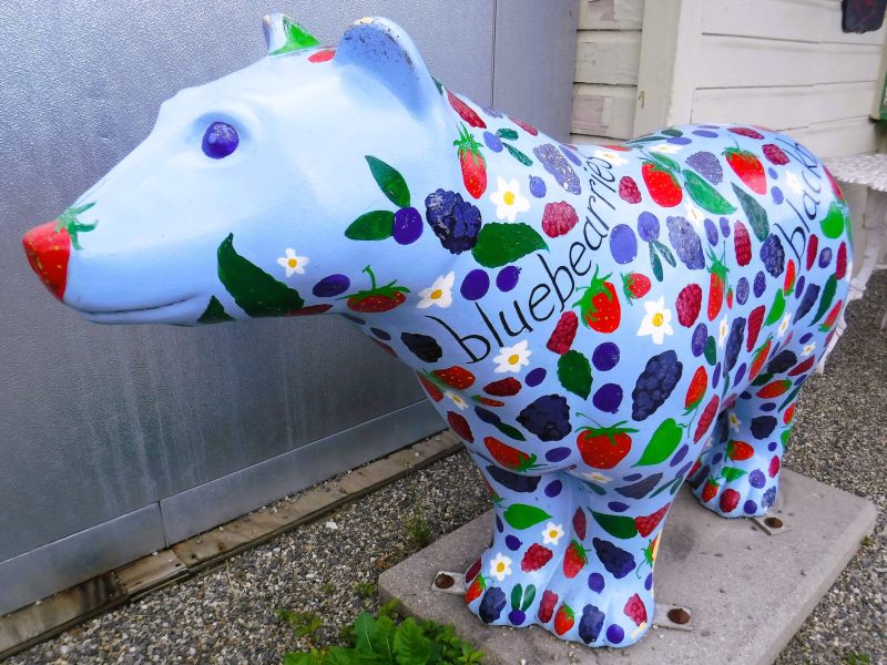 a statue of a bear with fruit painted on it.