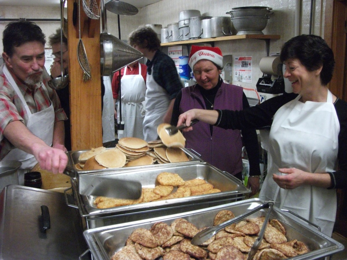 People make breakfast in a kitchen.