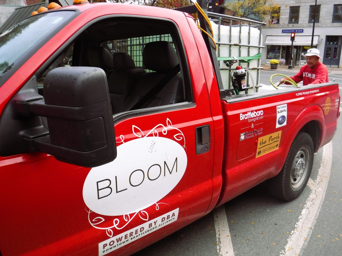 A red truck with a man in the back.