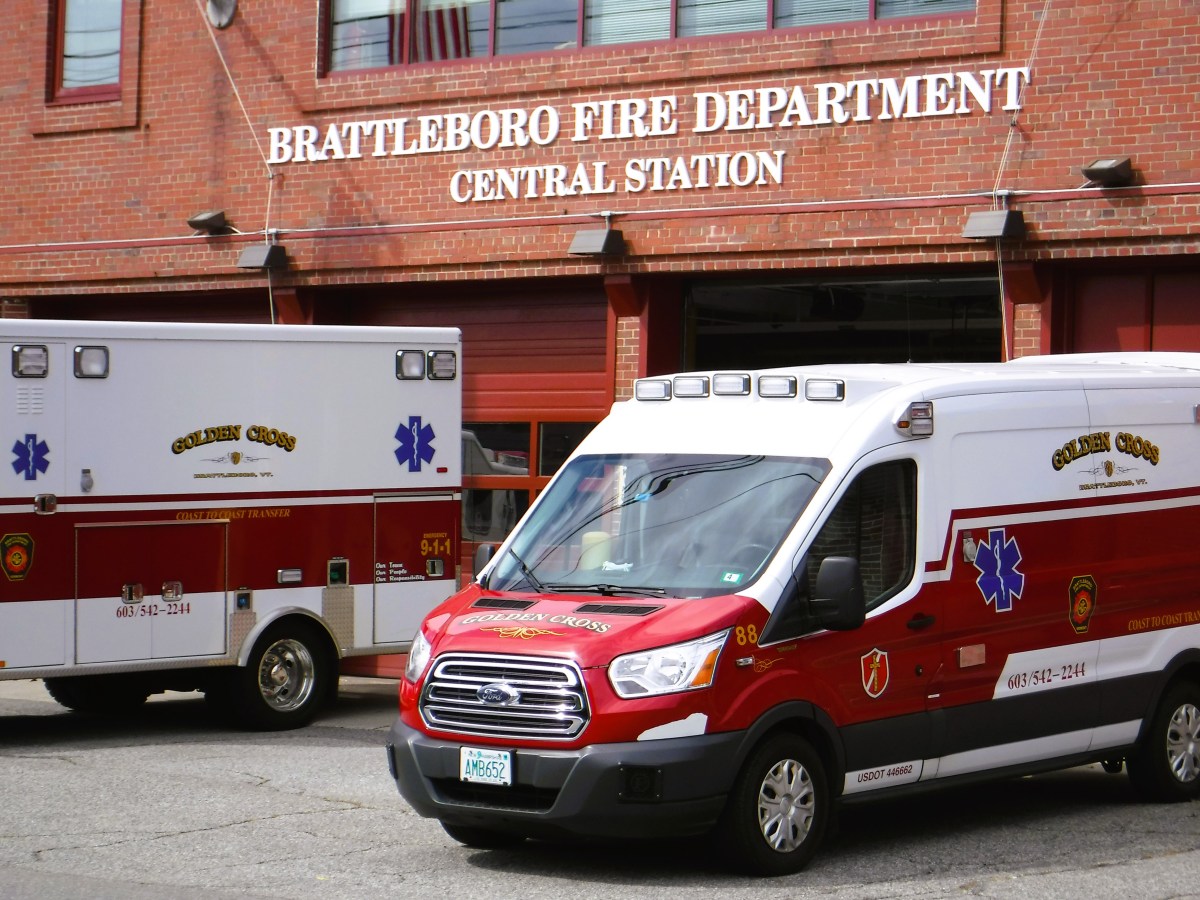 two ambulances parked in front of a fire department.