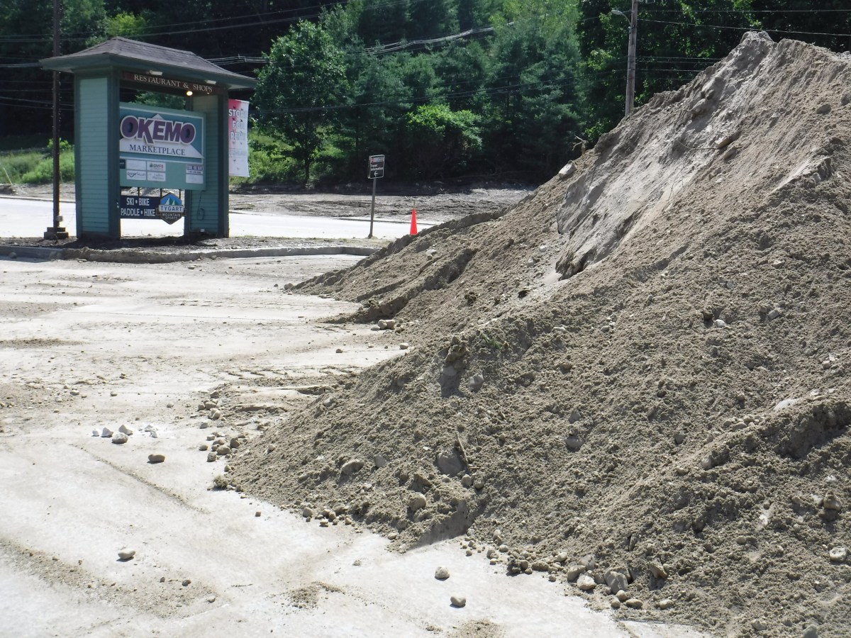 a pile of sand in front of a gas station.