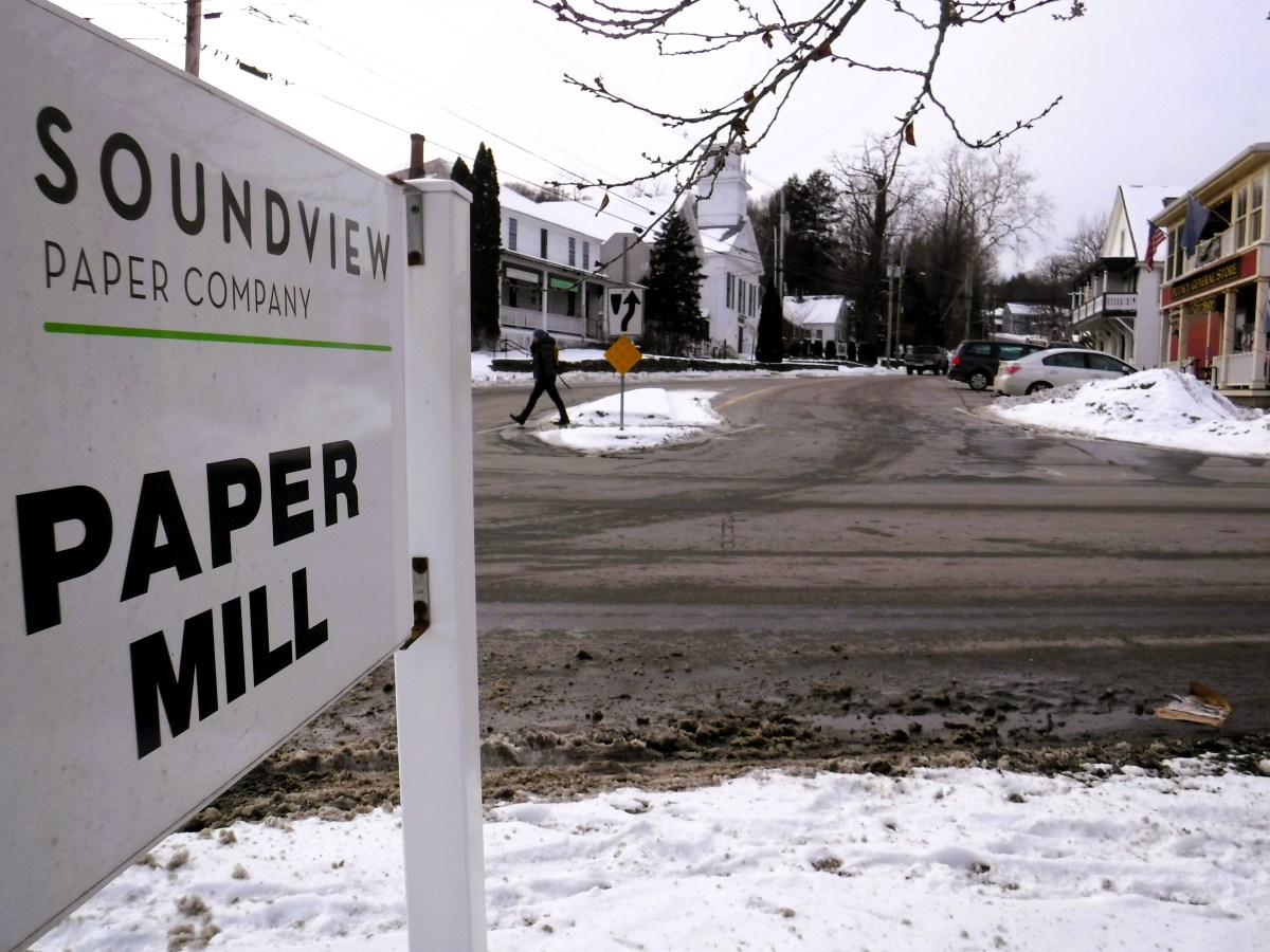 A sign for soundview paper mill on a snowy street.