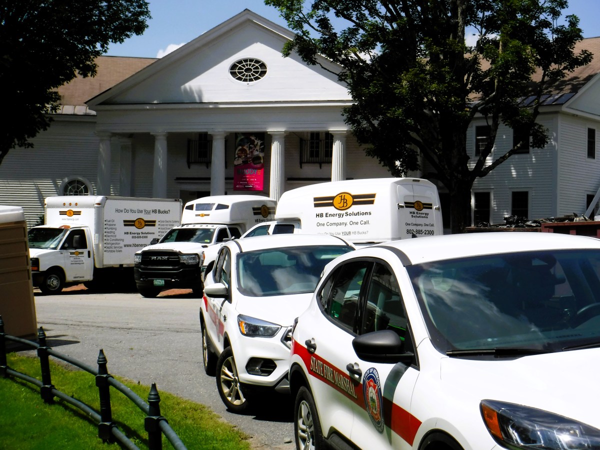 A white van parked in front of a white building.