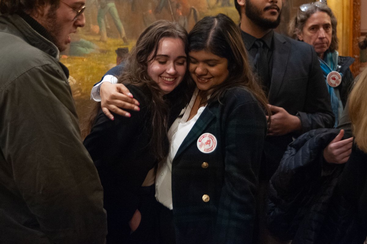 Two people hugging within a crowd