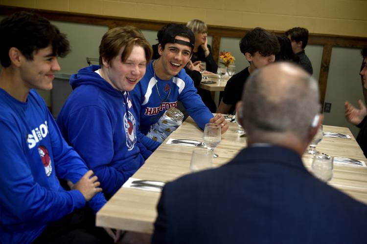 Students at lunch table with man