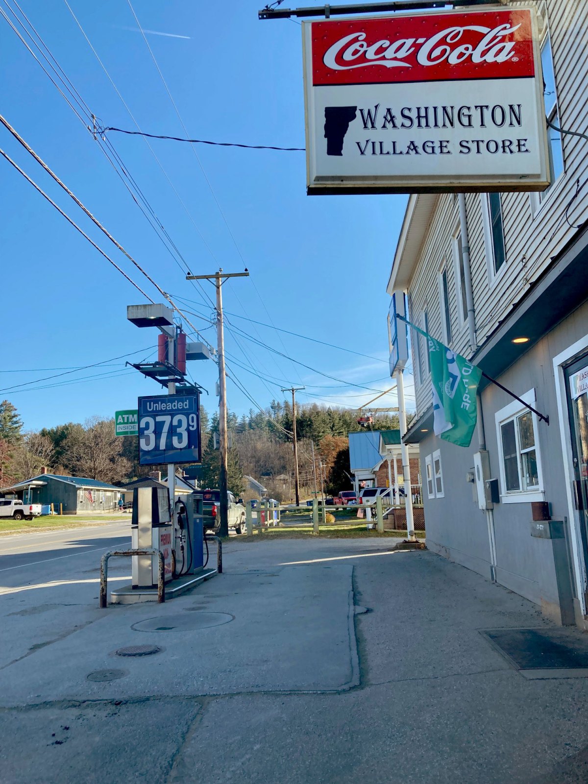 A gas station with a sign for coca cola.