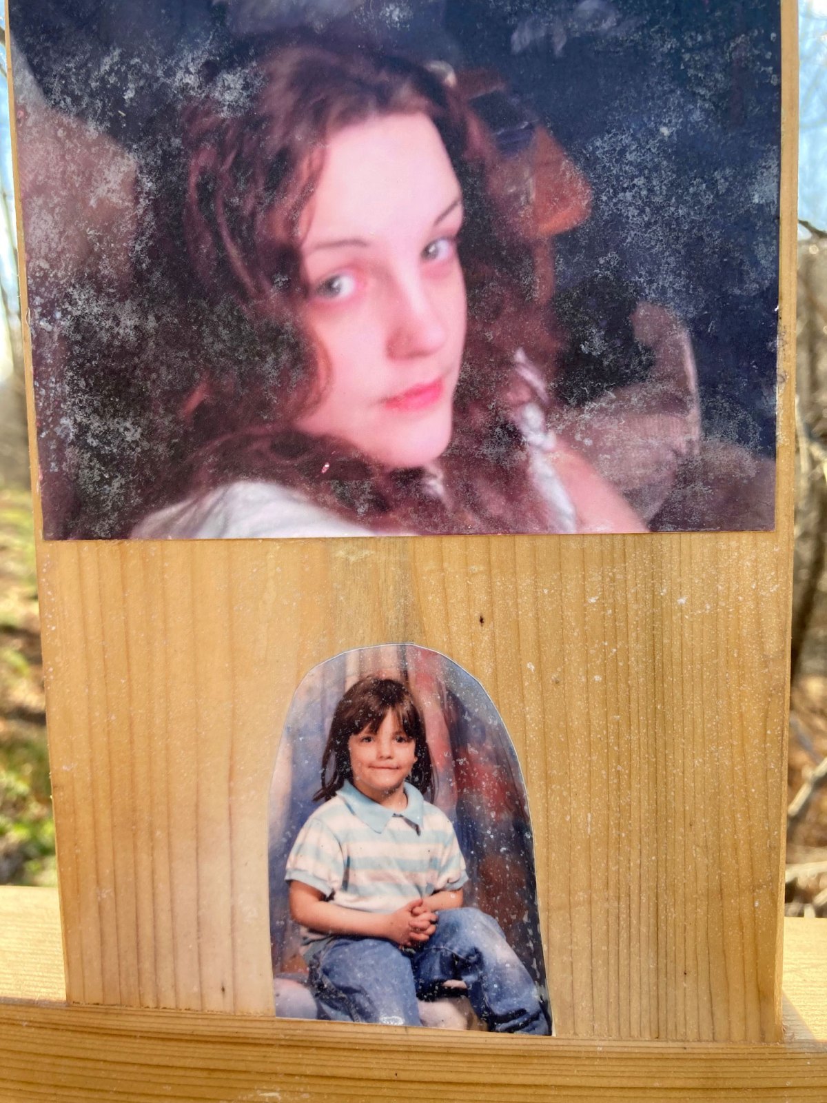 Photos of a girl affixed to a wooden cross