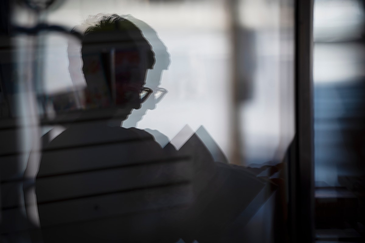 The reflection of a person in a glass door.