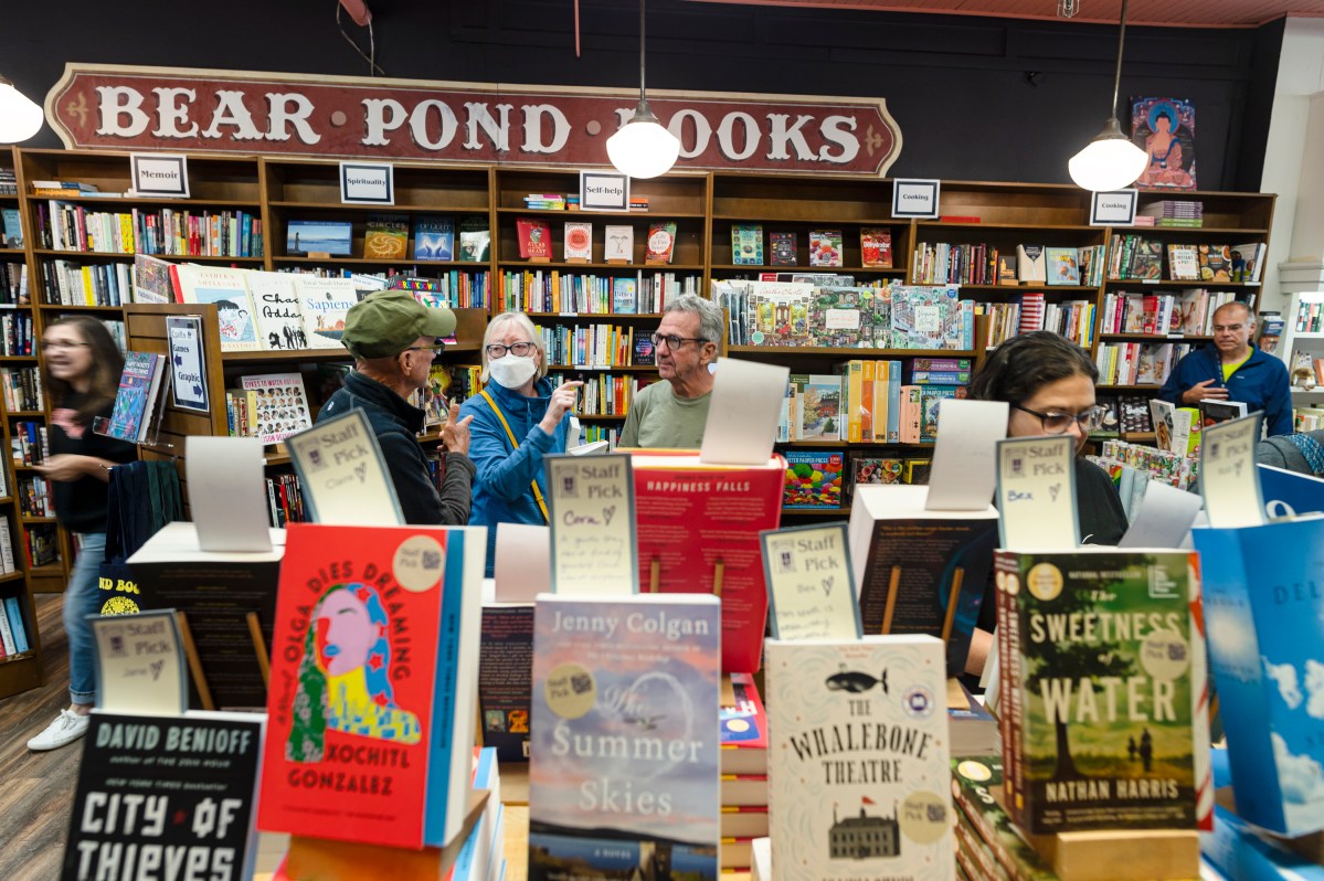 Customers look through shelves of books at a bookstore.