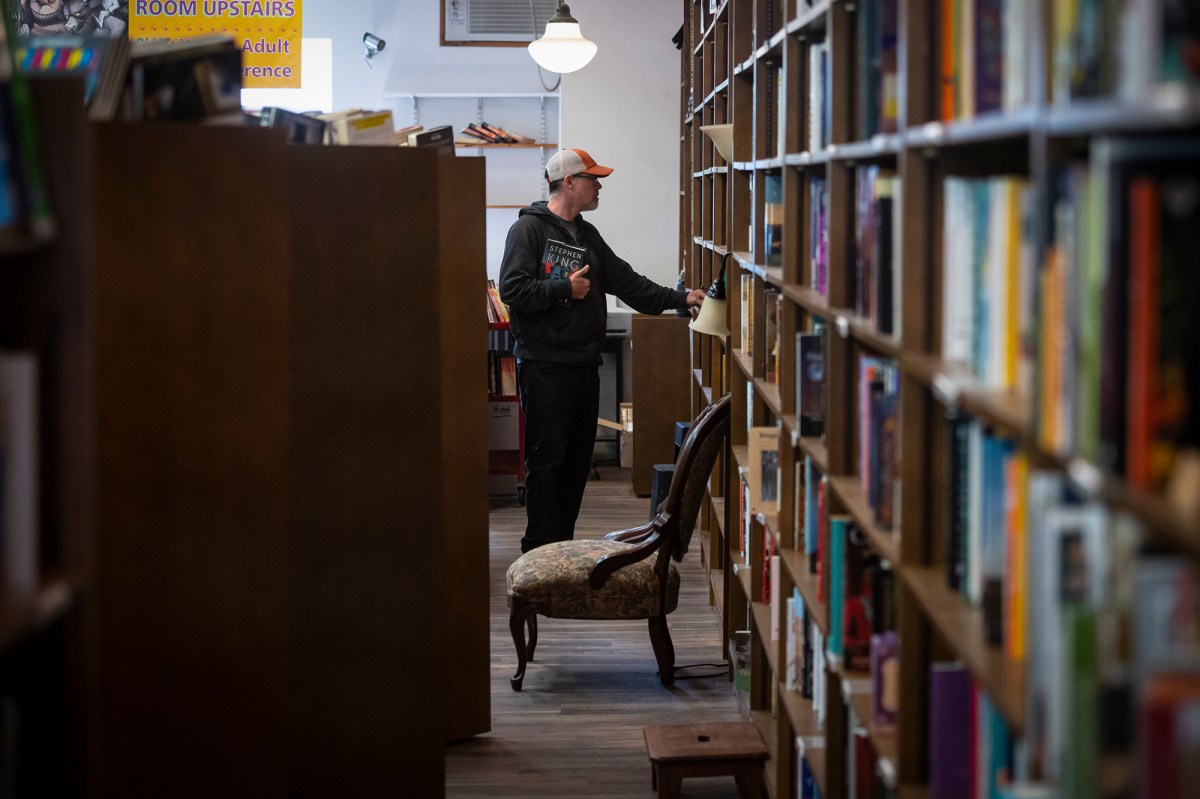 A man standing in a book store.