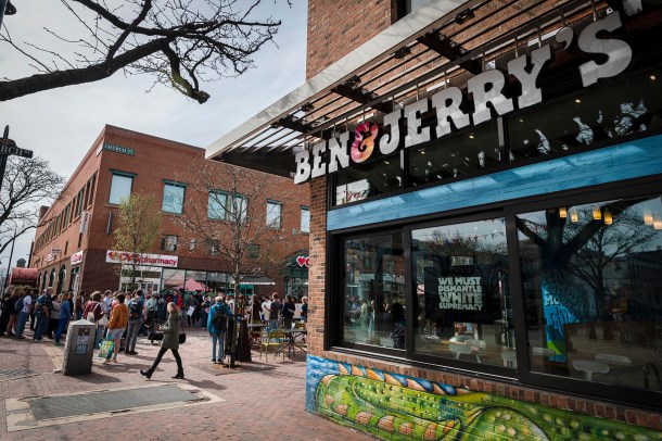A Ben & Jerry's store on a brick street with people in front.