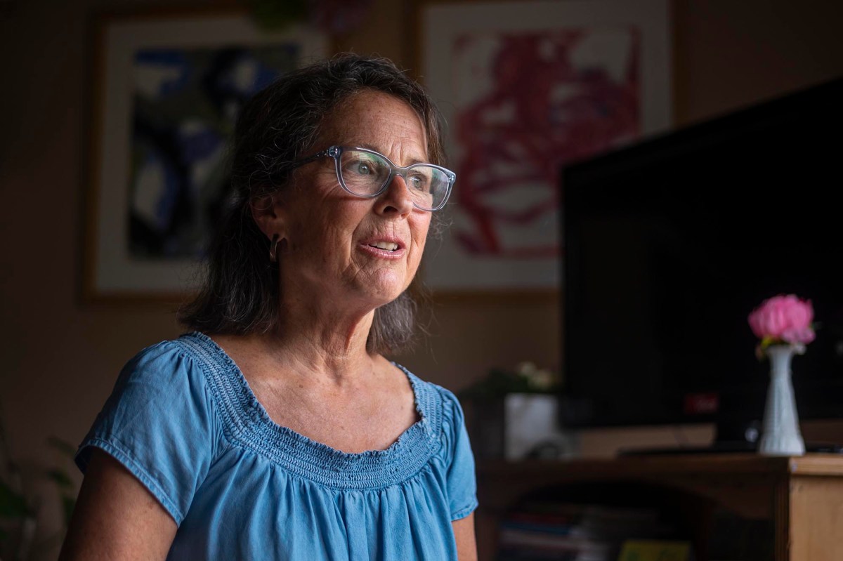 a woman wearing glasses sitting in front of a tv.