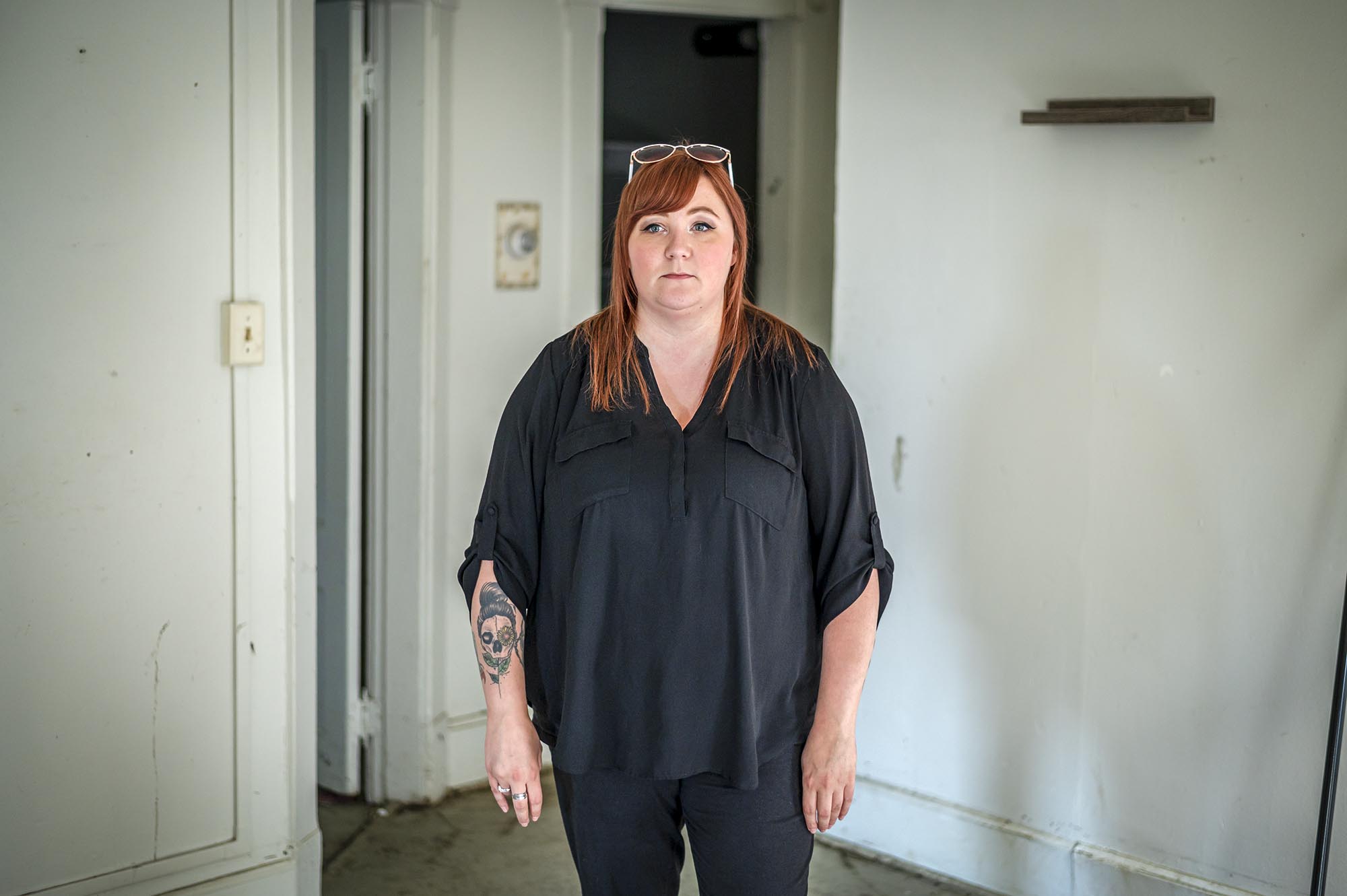 A woman in a black shirt standing in an empty room.