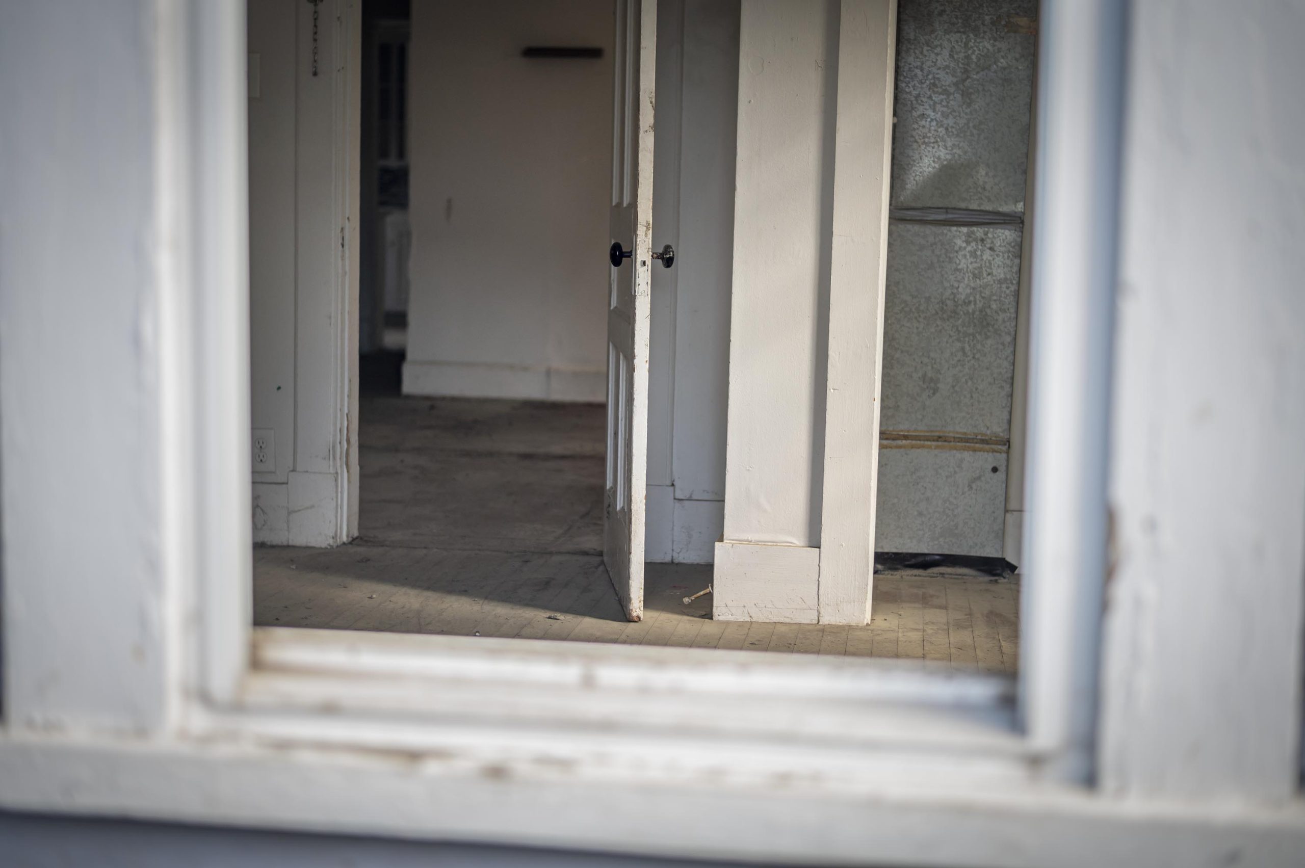 A room with a door and a mirror in it.