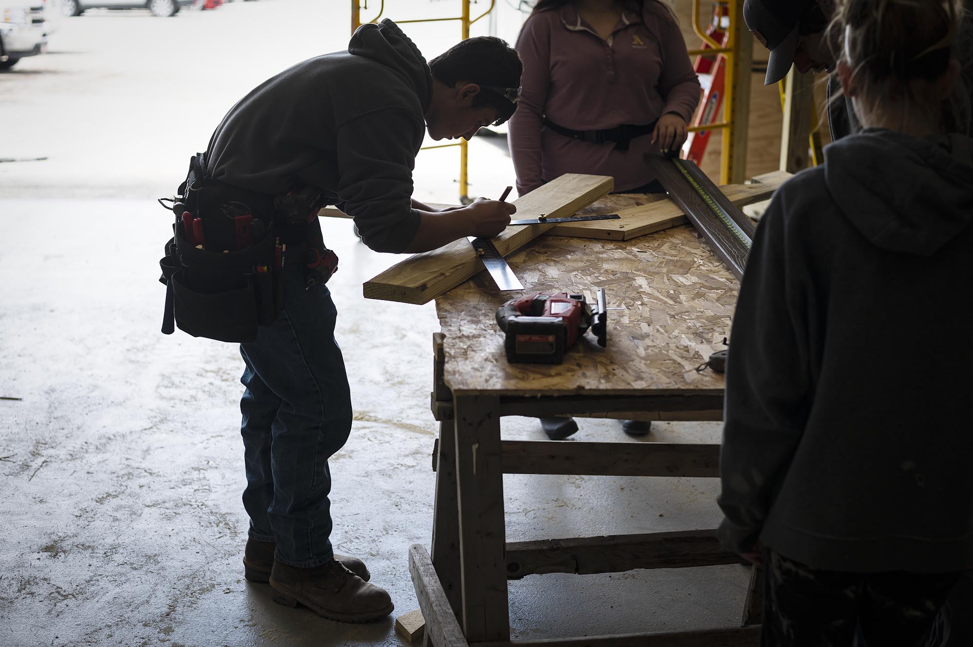 a young man is working on a piece of wood.