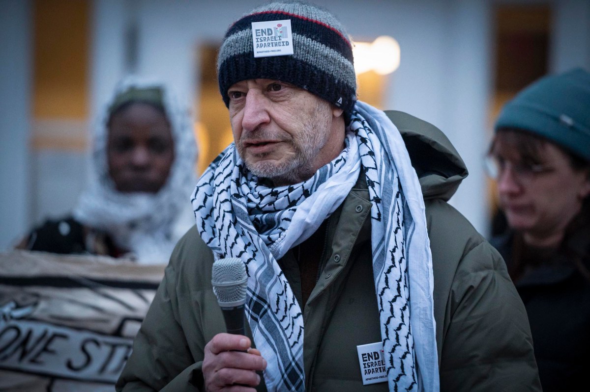 A man holding a microphone in front of a group of people.