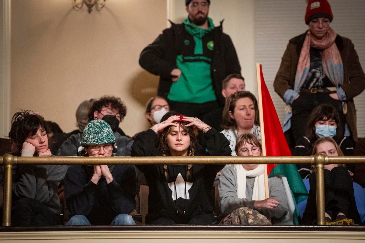 A group of people sitting in a room holding flags.