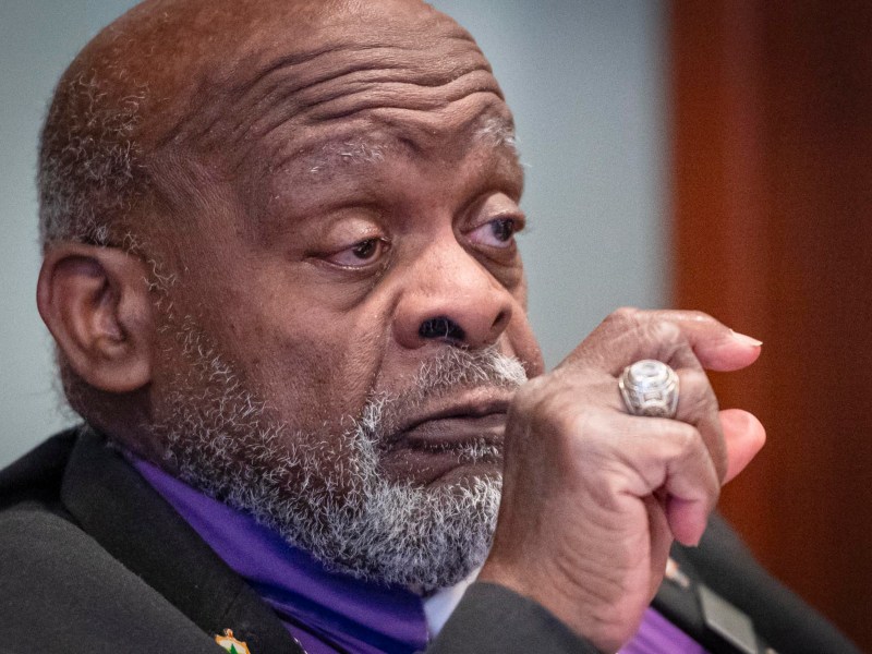 A man with a beard and a purple jacket.