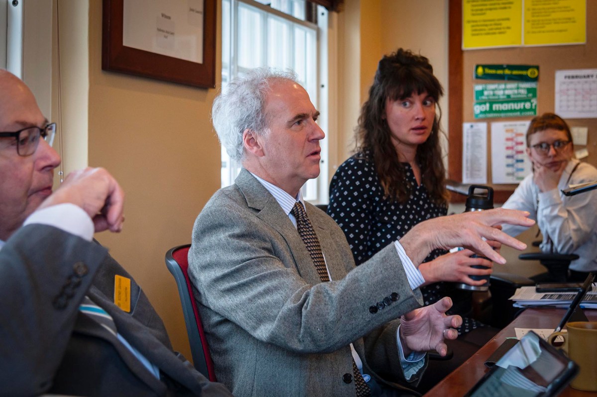 A group of people sitting around a table talking.