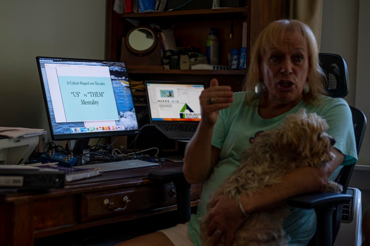 A woman sitting in a chair holding a dog.