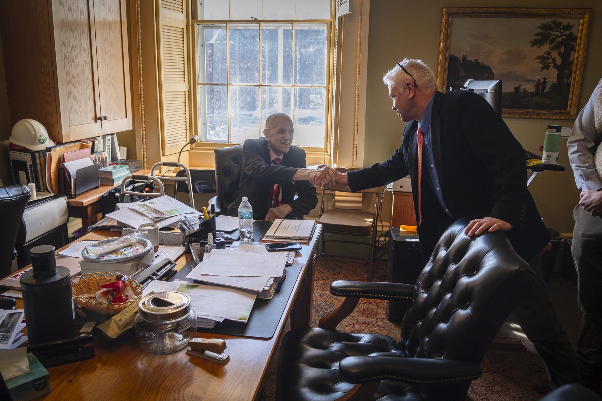 A man in a suit shaking hands with a man in a suit.