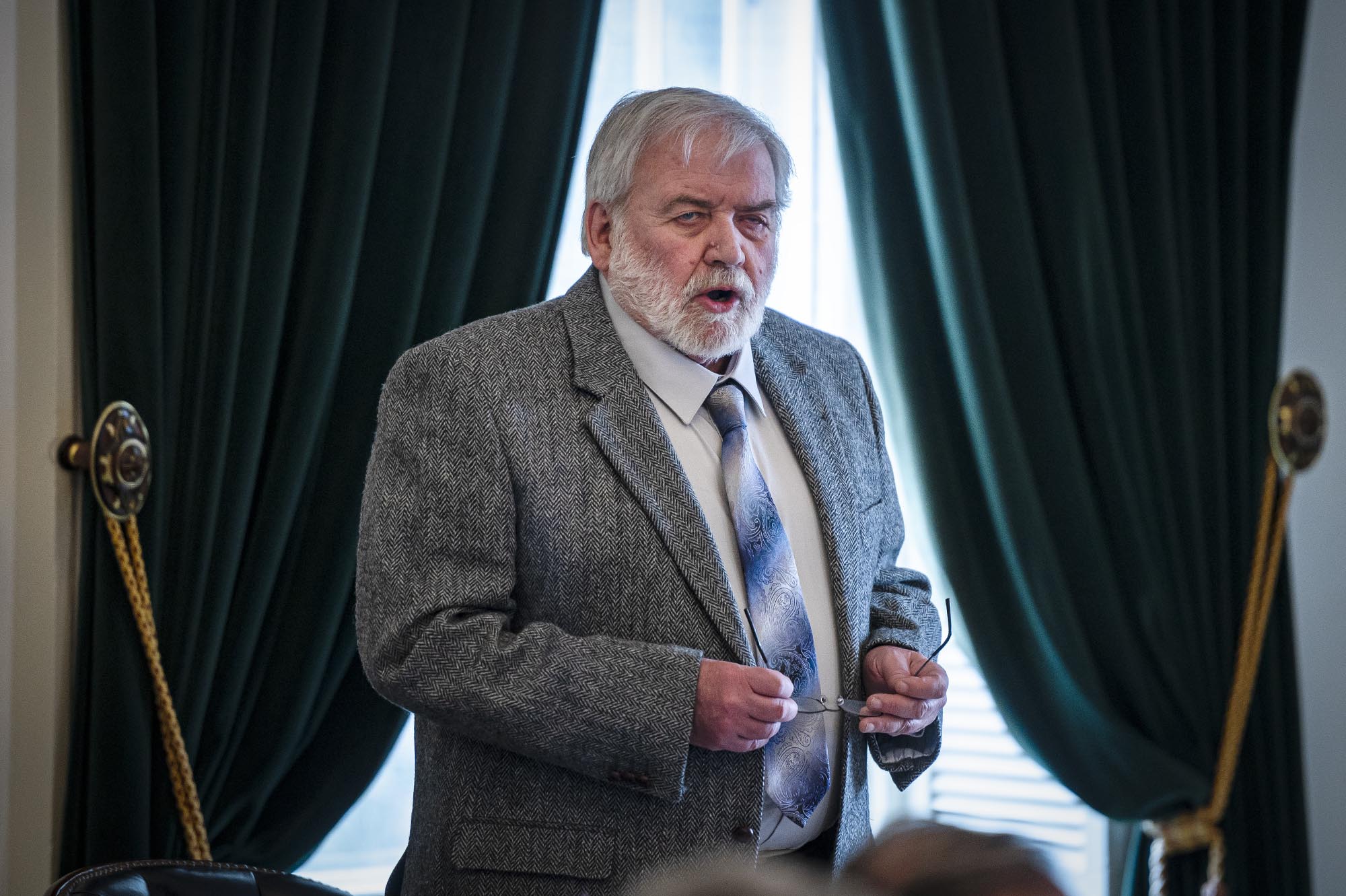 A man in a suit and tie giving a presentation.
