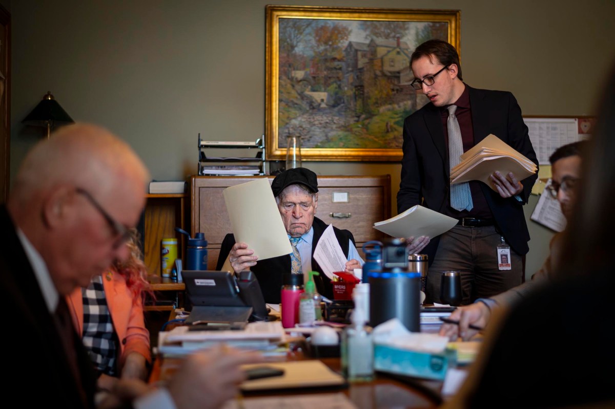 A group of people sitting around a table with papers.