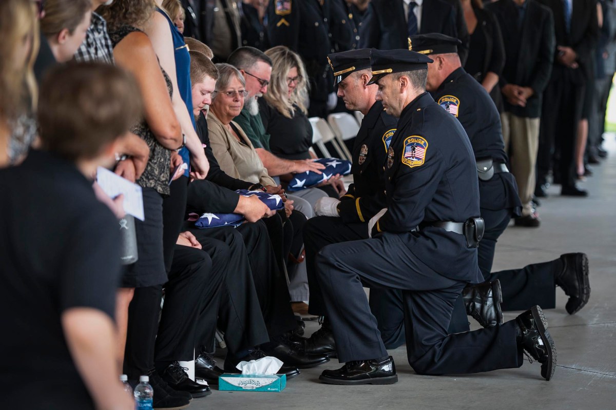 a group of police officers kneeling in front of a group of people.