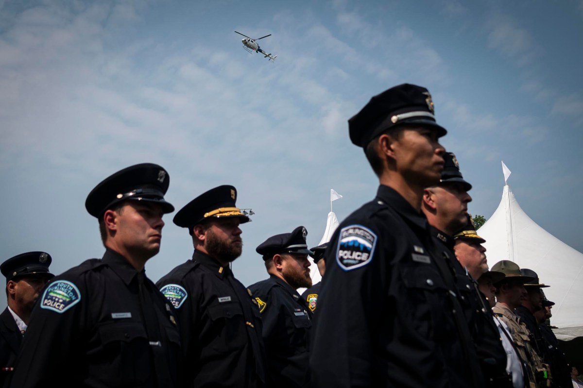 a group of police officers standing in front of a plane.