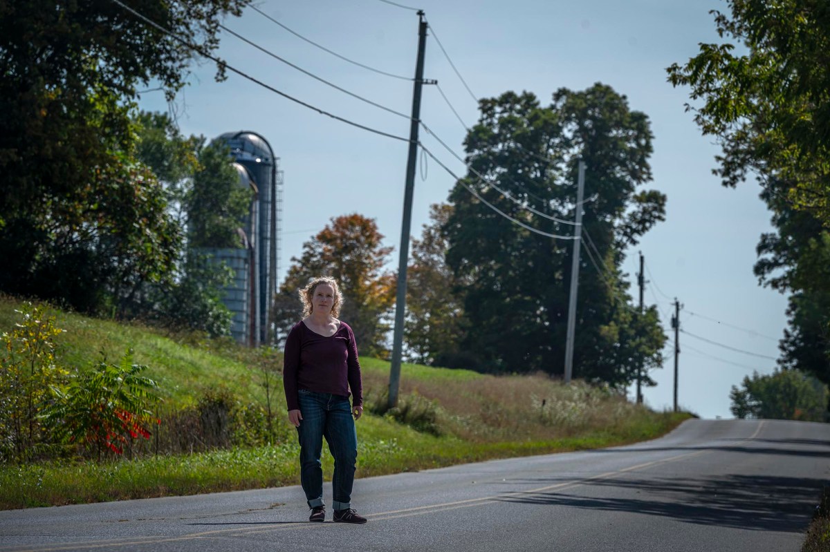 A woman standing on the side of a road.