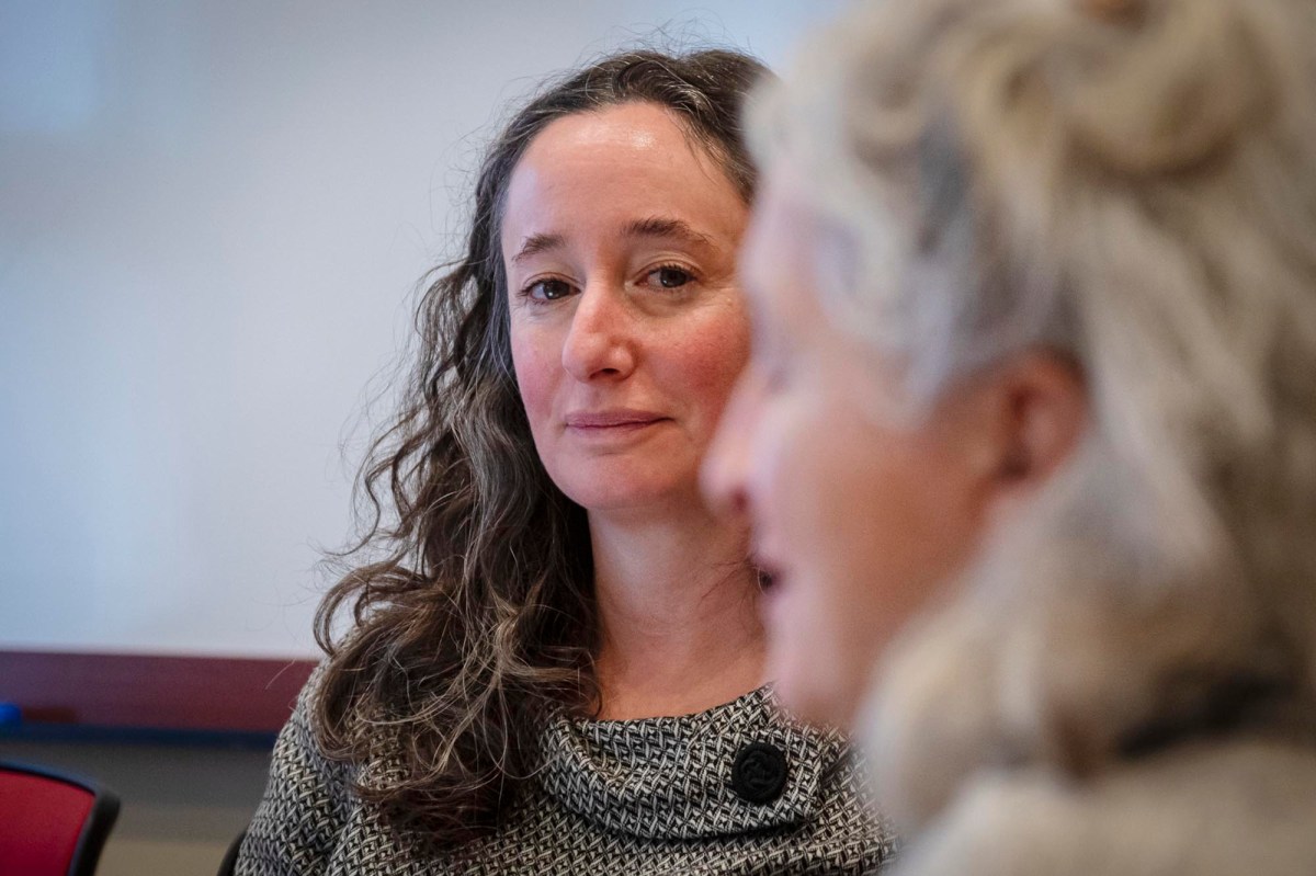 Two women sitting in a room talking to each other.