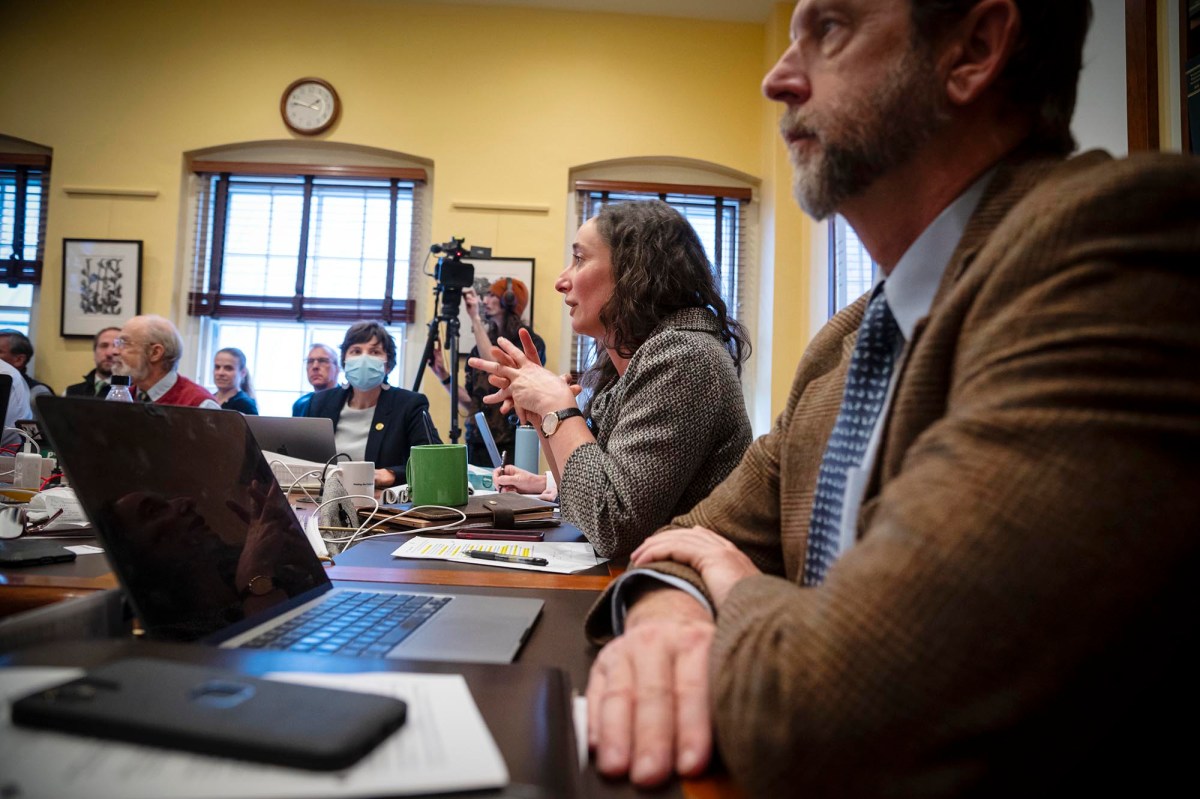 A group of people sitting at a table with laptops.