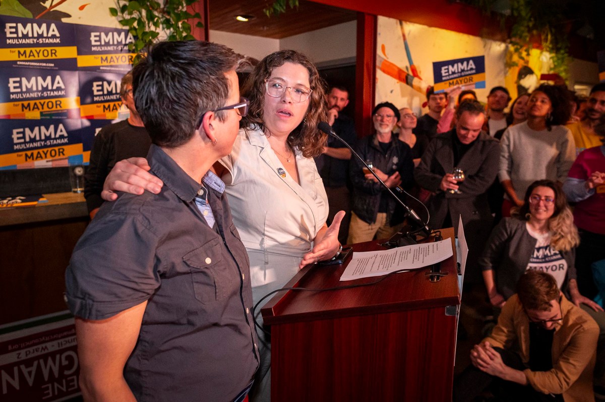 Two women standing at a podium in front of a crowd.