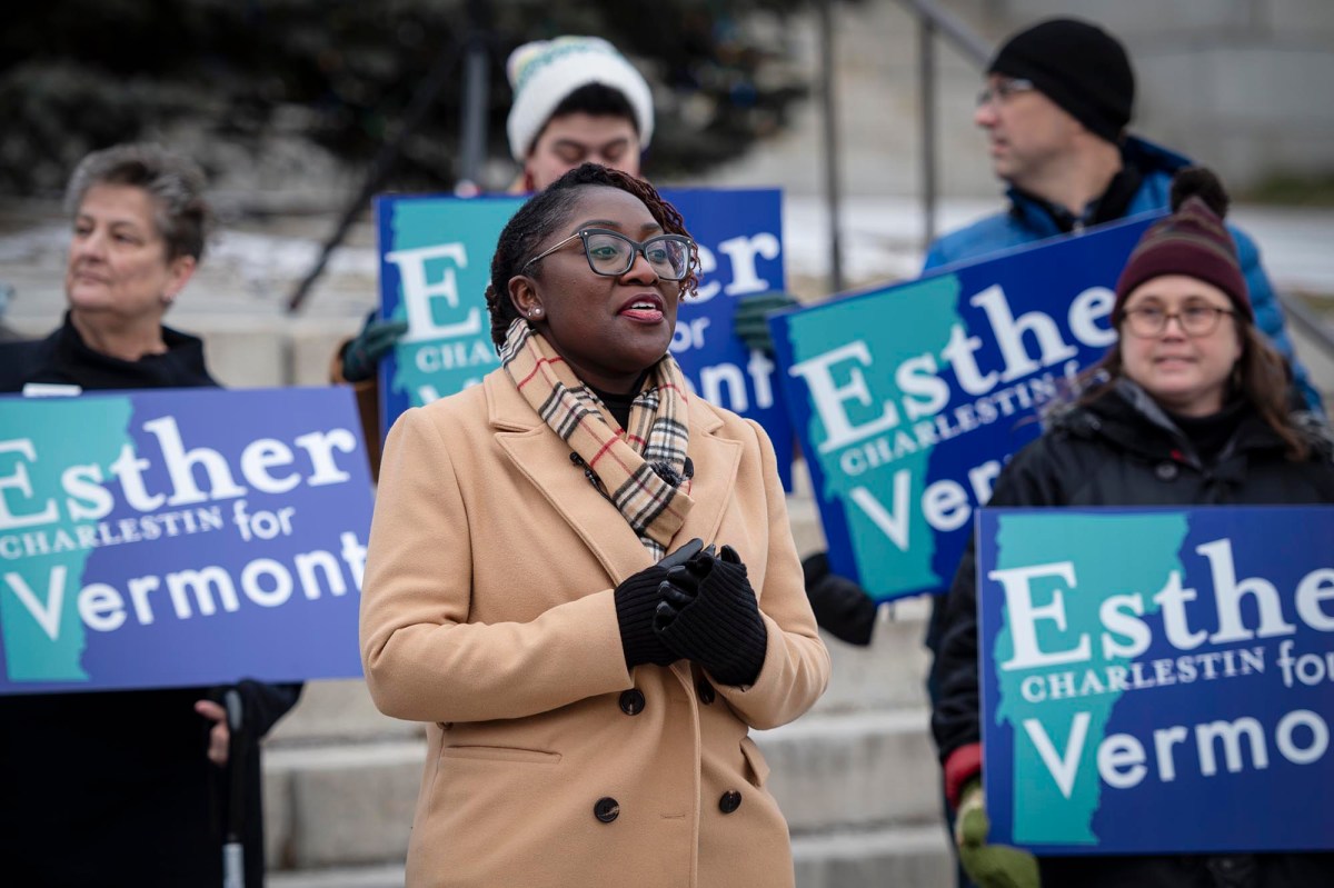 A group of people standing in front of a sign that says esther for vermont.