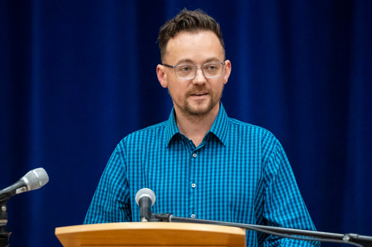 A man with glasses standing at a podium.