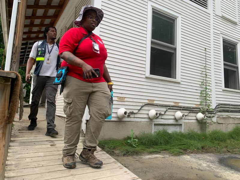 Two FEMA employees outside of a house.